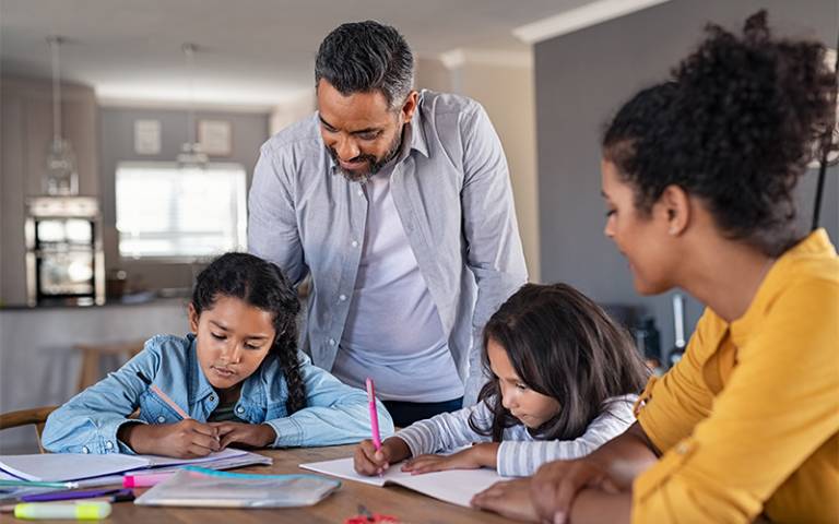 Parents overlooking their kids in homework