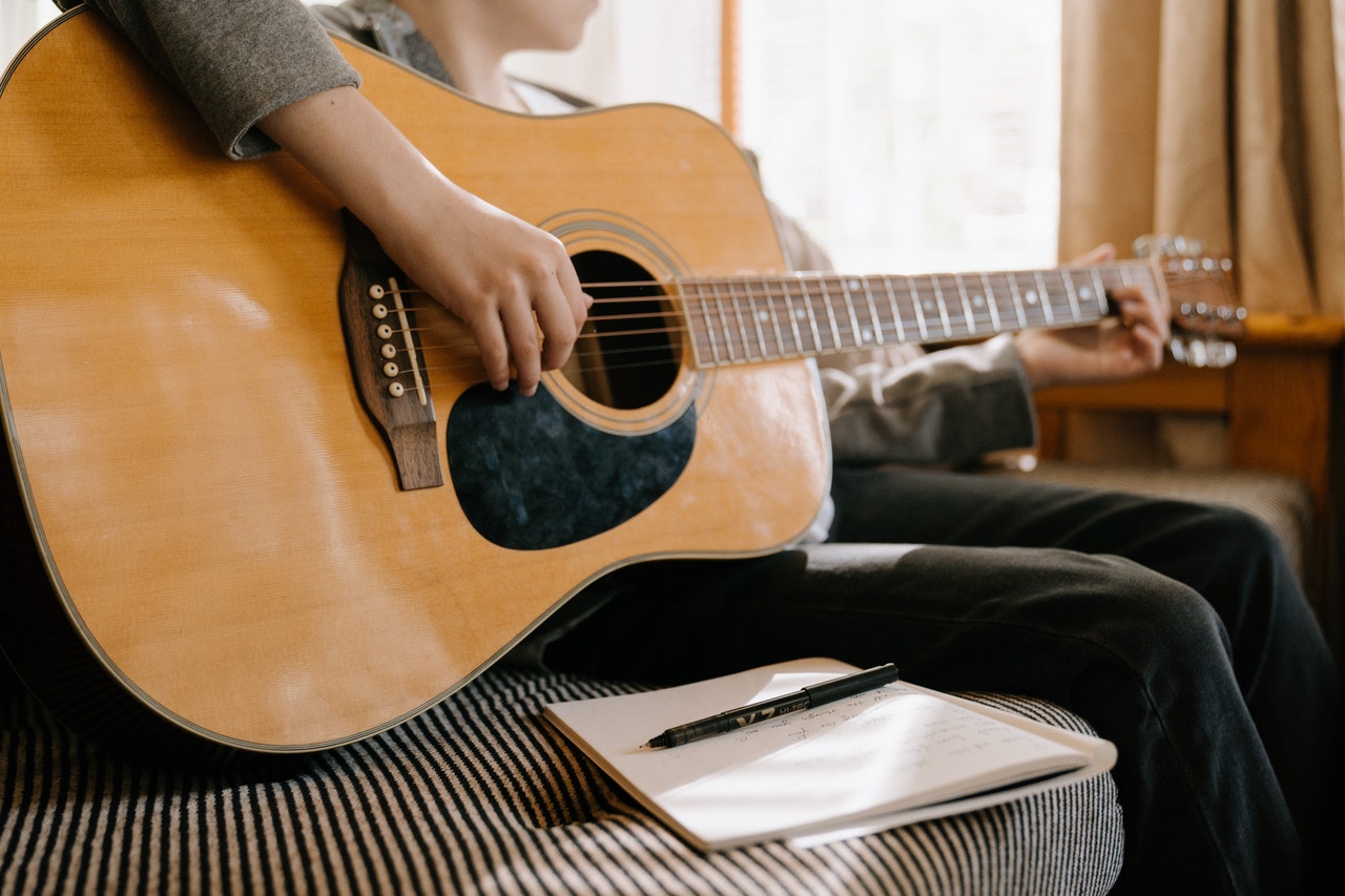 Man with a guitar to apply Six Sigma for songwriting