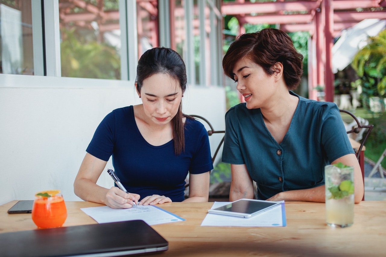 Two women writing - and planning for Six Sigma Resume Writing techniques