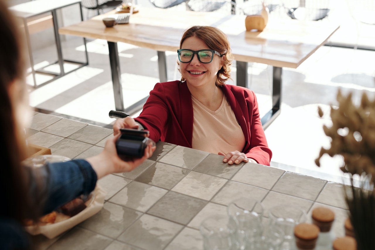 Woman taking stuff happily at retail counter